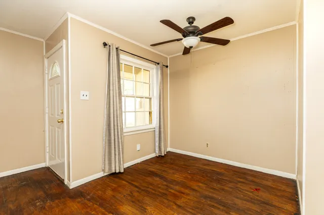 a view of a livingroom with wooden floor and a ceiling fan