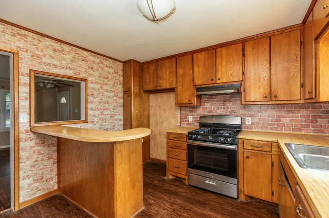 a kitchen with stainless steel appliances granite countertop a stove a sink and a refrigerator