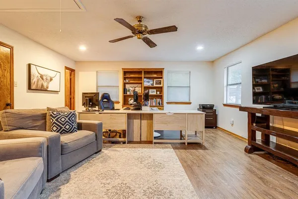a living room with furniture and a flat screen tv with kitchen view
