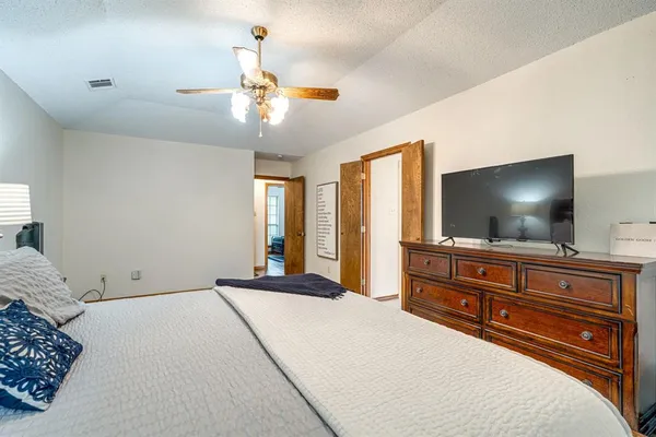 a bedroom with a large bed and a flat screen tv