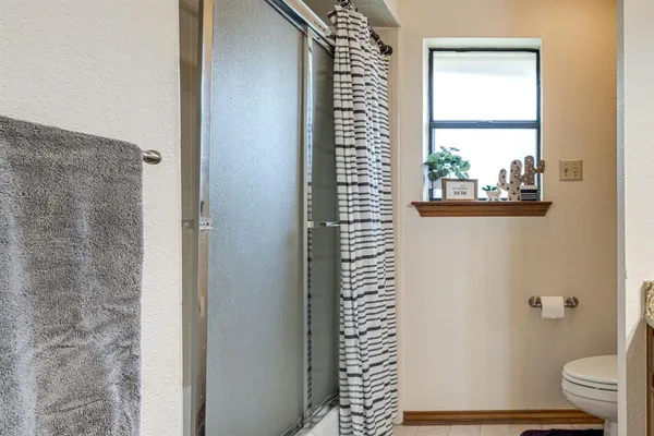 a bathroom with a window and a shower