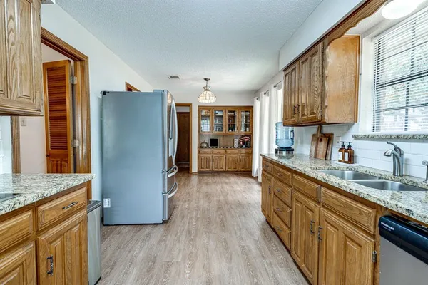 a kitchen with stainless steel appliances granite countertop a refrigerator and a sink