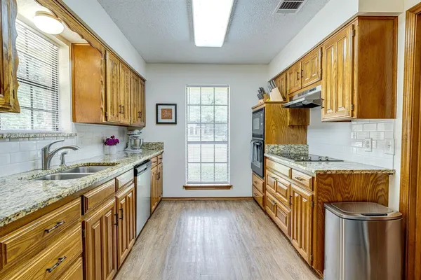 a kitchen with stainless steel appliances granite countertop a sink stove and refrigerator