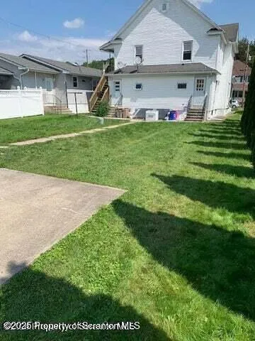 a view of a big house with a big yard and potted plants