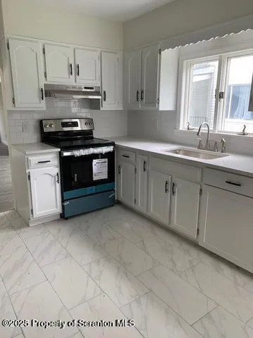 a kitchen with stainless steel appliances granite countertop a sink and cabinets