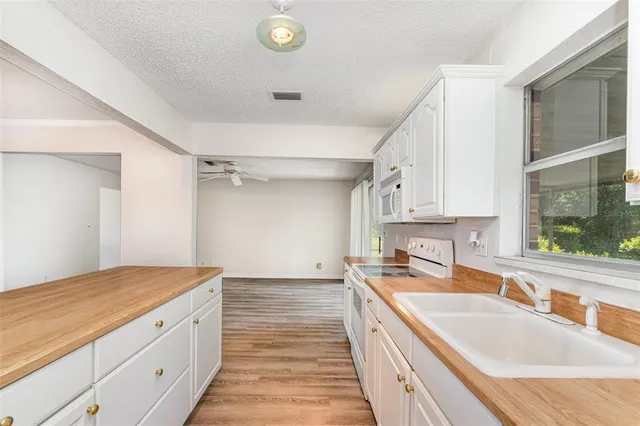 a kitchen with granite countertop a sink stove and cabinets