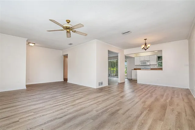 a view of a kitchen with a sink and dishwasher with wooden floor