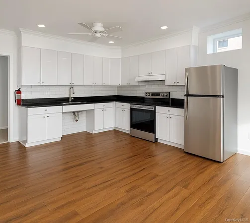 a kitchen with stainless steel appliances granite countertop a refrigerator sink and white cabinets