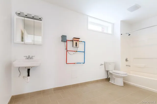 a bathroom with a toilet sink and mirror