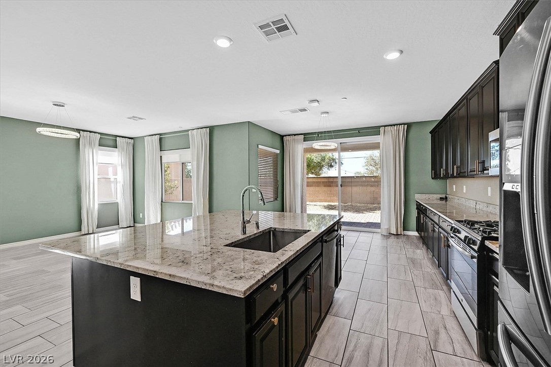 1106 Langston Ranch Avenue Henderson, NV 89002 - Photo 8 of 36 An inviting kitchen with a granite island, modern appliances, and abundant natural light.