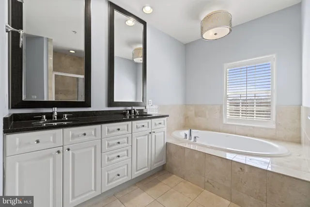 a bathroom with double vanity and a bathtub