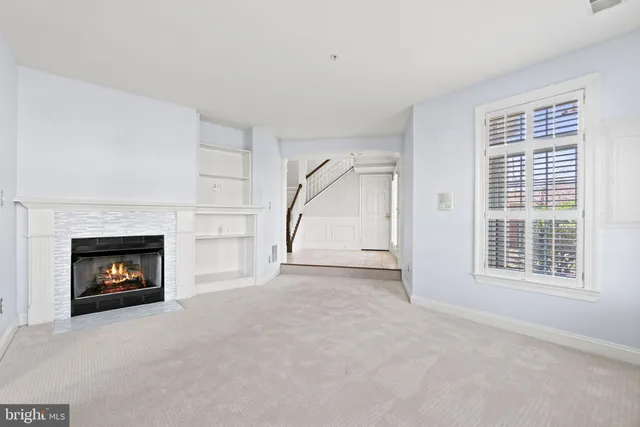 a view of an empty room with a window and fireplace