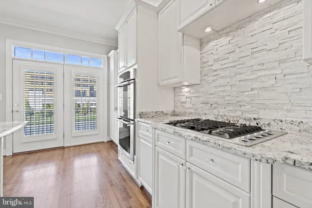 a kitchen with granite countertop a stove and a wooden floors