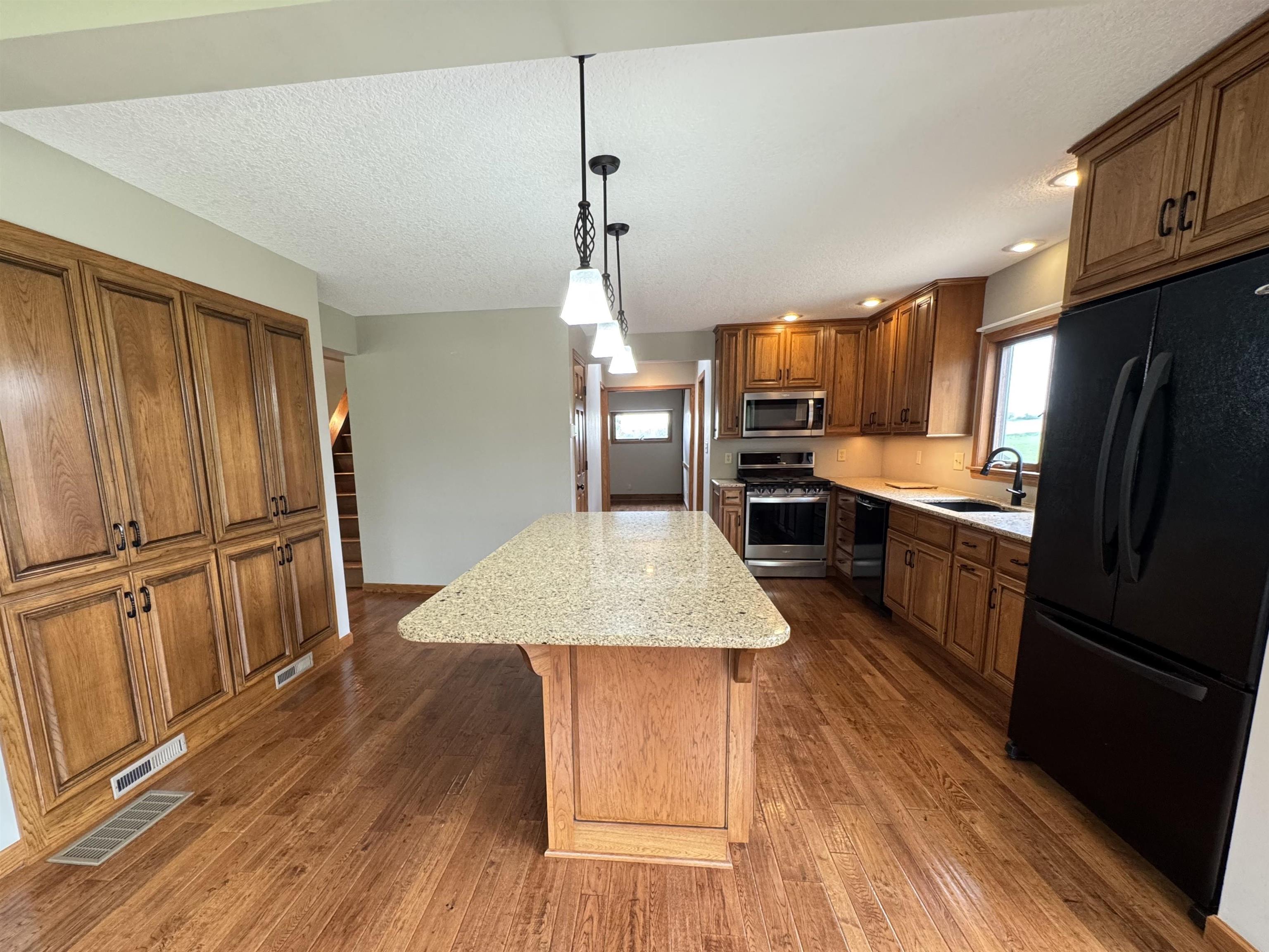 25303 Spring Valley Road Shannon, IL 61078 - Photo 12 of 22 a kitchen with kitchen island wooden floors appliances and cabinets