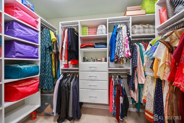 a view of walk in closet with clothes
