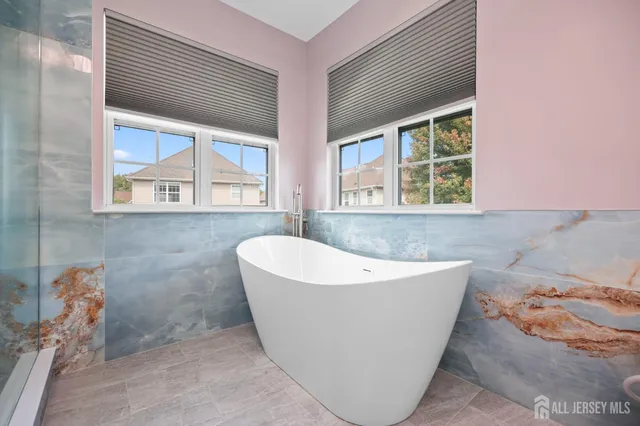 a white bath tub sitting in a bathroom next to a window