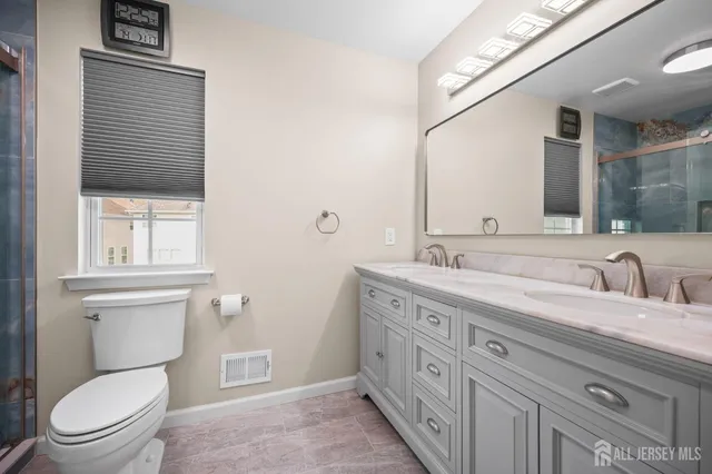 a bathroom with a toilet a sink and mirror