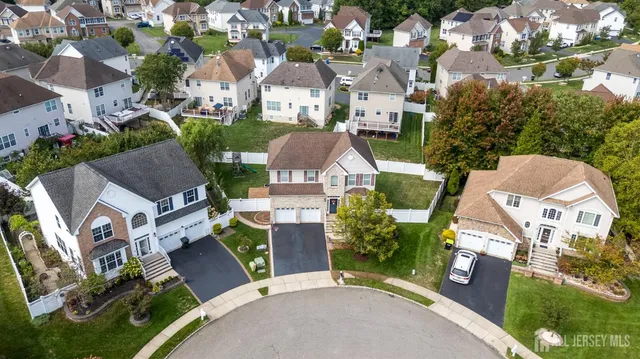 an aerial view of multiple houses with a yard