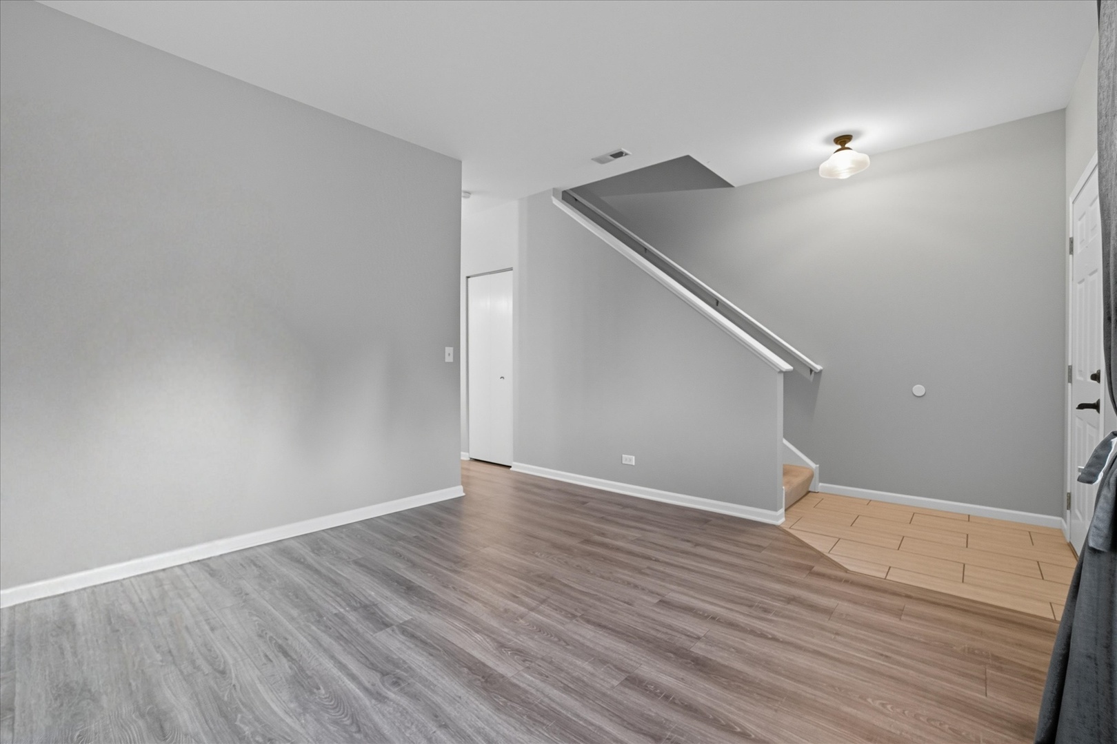 819 Daniel Drive Minooka, IL 60447 - Photo 9 of 33 a view of an empty room with wooden floor and stairs
