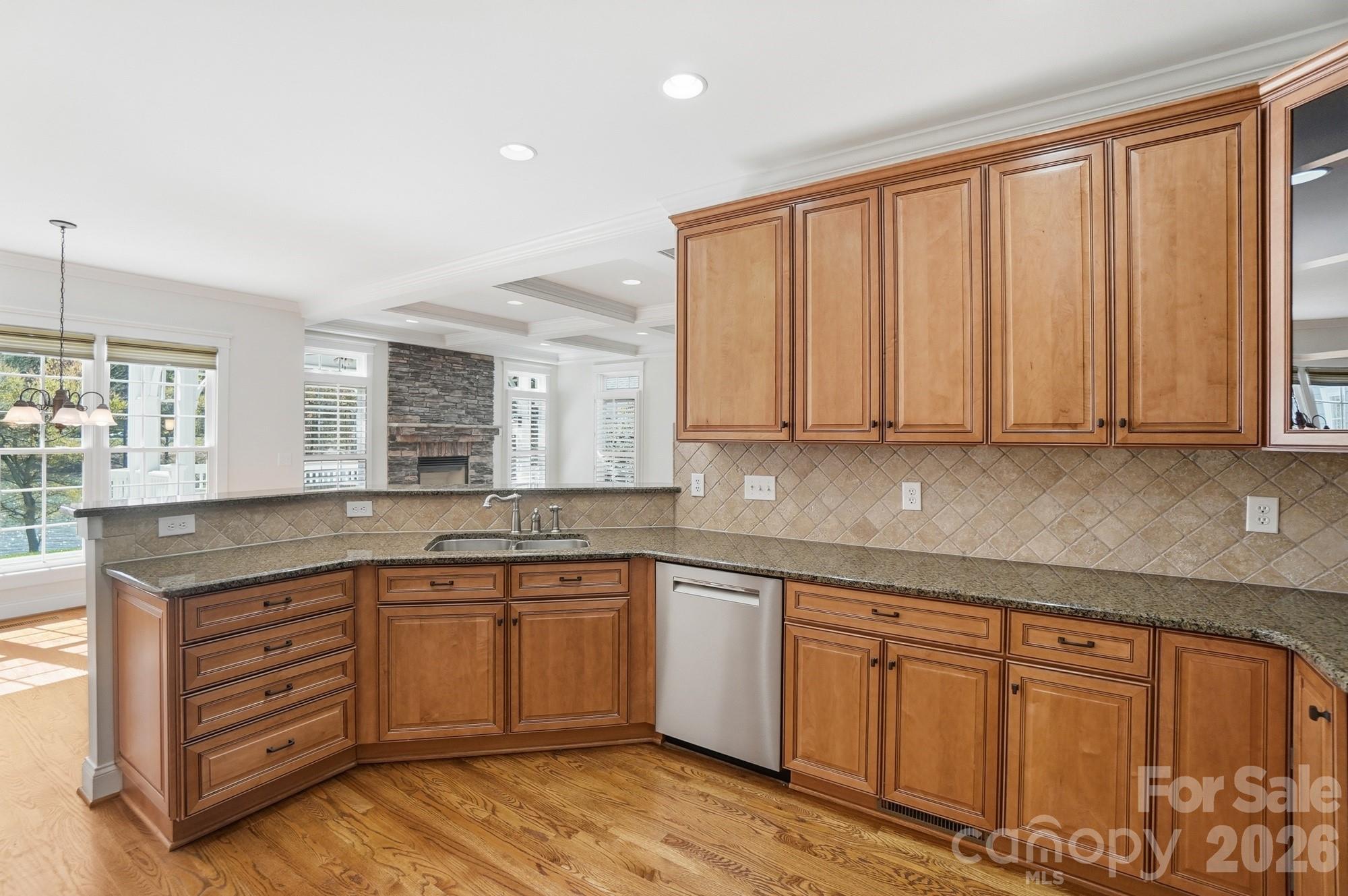 159 Lavender Bloom Loop Mooresville, NC 28115 - Photo 16 of 48 a kitchen with stainless steel appliances granite countertop a stove a sink and white cabinets with wooden floor