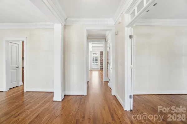 an empty room with wooden floor fireplace and windows