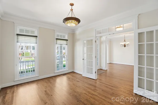 a view of a hallway with wooden floor and windows