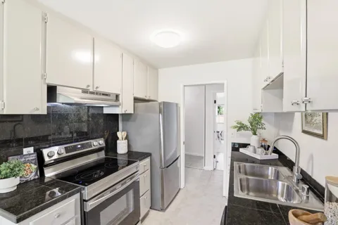 a kitchen with stainless steel appliances a stove a sink a refrigerator and cabinets