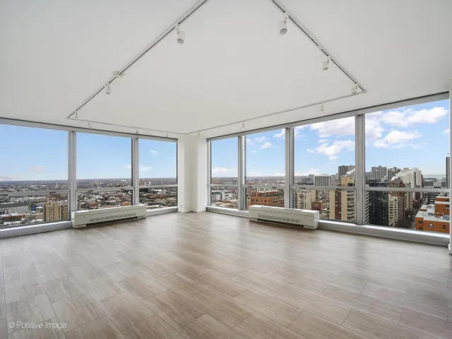 a view of room with wooden floor and floor to ceiling window