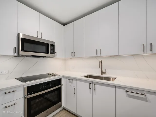a kitchen with cabinets stainless steel appliances and a sink