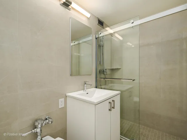 a bathroom with a sink mirror and shower