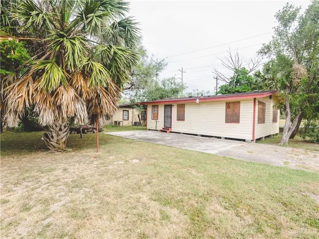 a backyard of a house with table and chairs