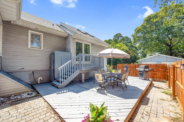 a view of a roof deck with table and chairs under an umbrella with wooden floor