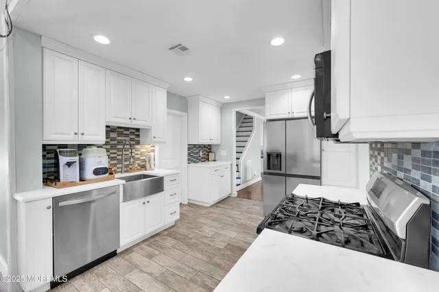 a kitchen with white cabinets and appliances