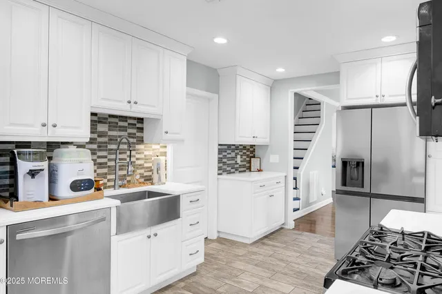 a kitchen with white cabinets and stainless steel appliances