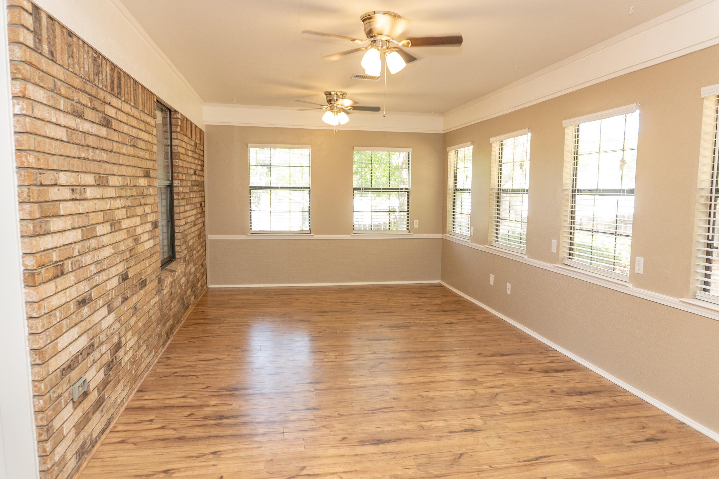 102 Brian Drive Crestview, FL 32536 - Photo 12 of 23 a view of an empty room with wooden floor and a window