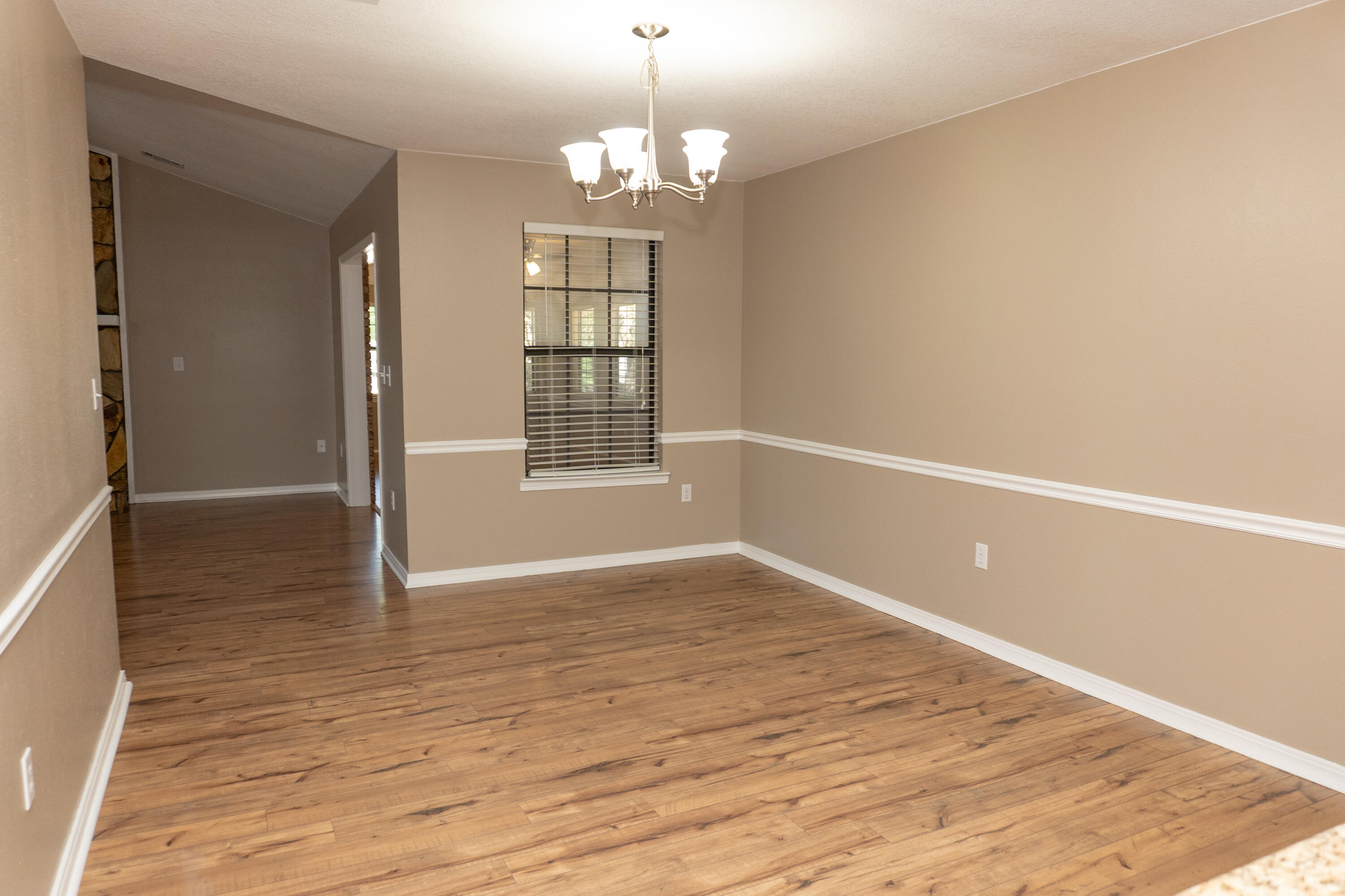 102 Brian Drive Crestview, FL 32536 - Photo 8 of 23 wooden floor in an empty room with a window