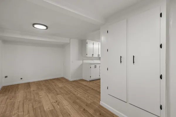 a view of empty room with wooden floor