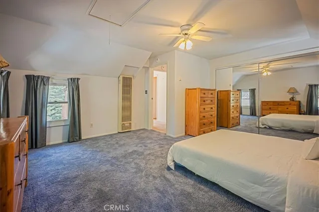 a bedroom with a large bed a flat tv screen and dresser