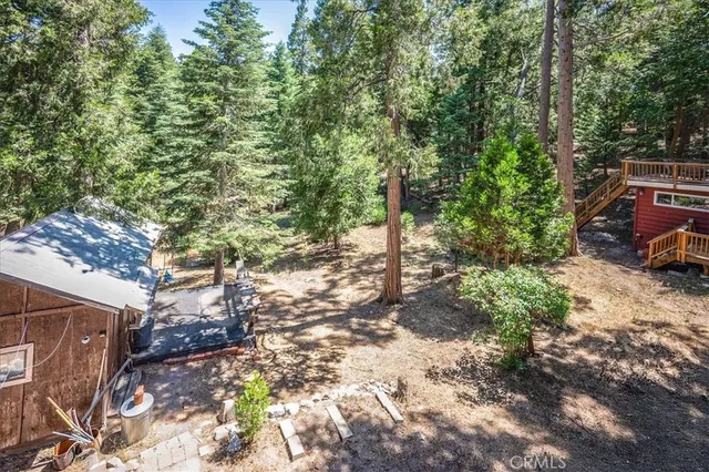 a backyard of a house with large trees and outdoor seating