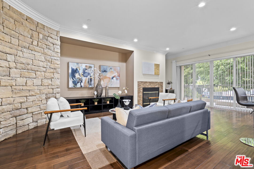a living room with fireplace furniture and a large window