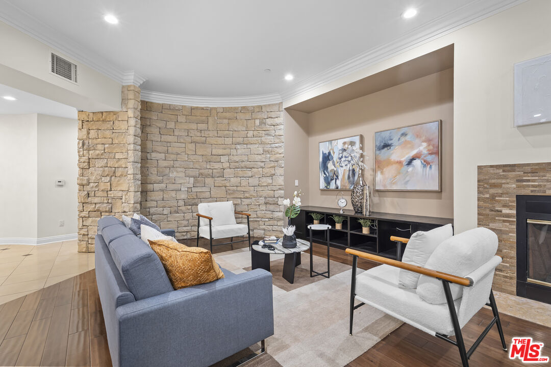 4848 Wilshire Boulevard, Unit 102 Los Angeles, CA 90036 - Photo 11 of 47 a living room with furniture a rug and a fireplace
