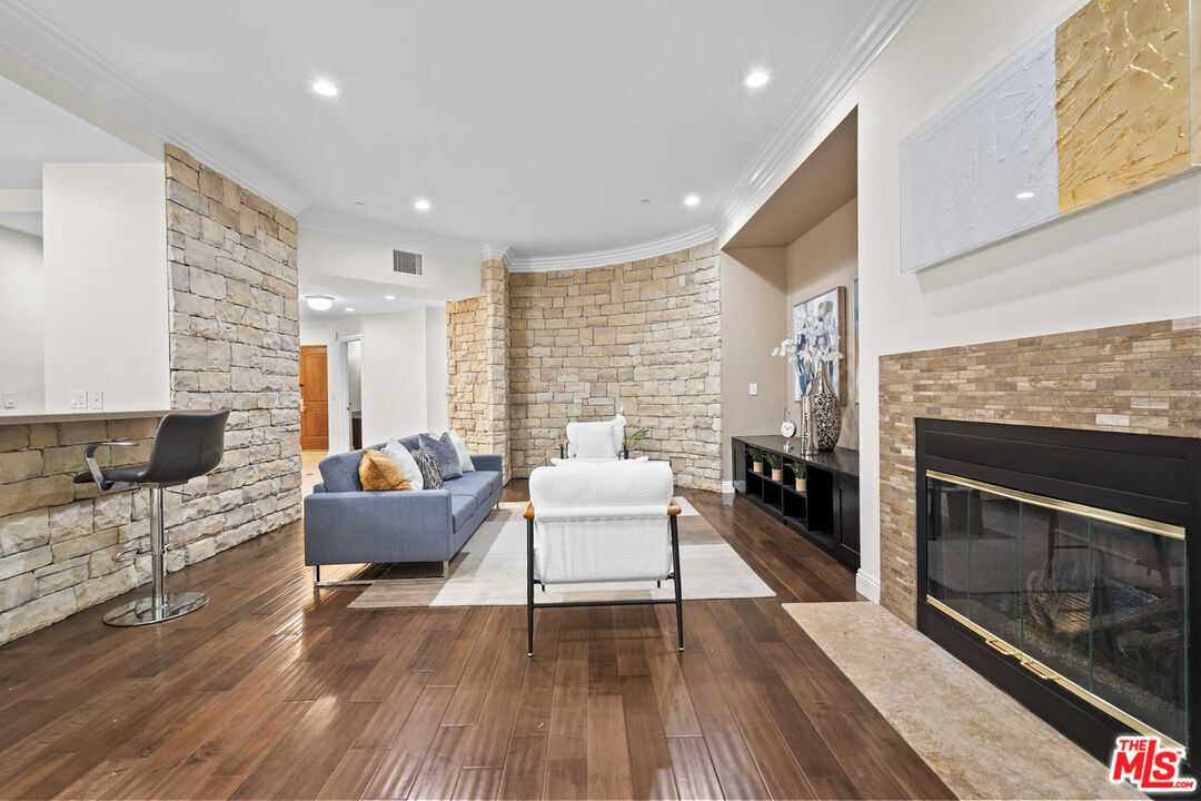 4848 Wilshire Boulevard, Unit 102 Los Angeles, CA 90036 - Photo 14 of 47 a living room with furniture wooden floor and a fireplace