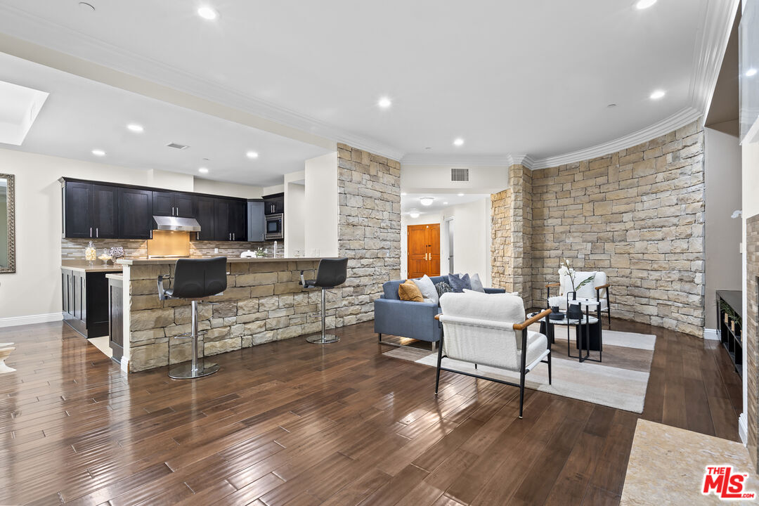 4848 Wilshire Boulevard, Unit 102 Los Angeles, CA 90036 - Photo 15 of 47 a living room with furniture and kitchen view with wooden floor