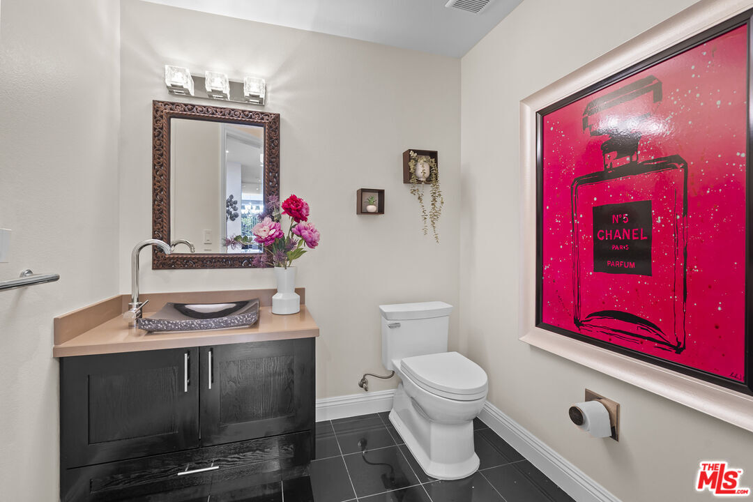 4848 Wilshire Boulevard, Unit 102 Los Angeles, CA 90036 - Photo 18 of 47 a bathroom with a toilet sink vanity and mirror