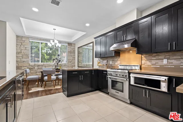 a kitchen with a dining table chairs and chandelier