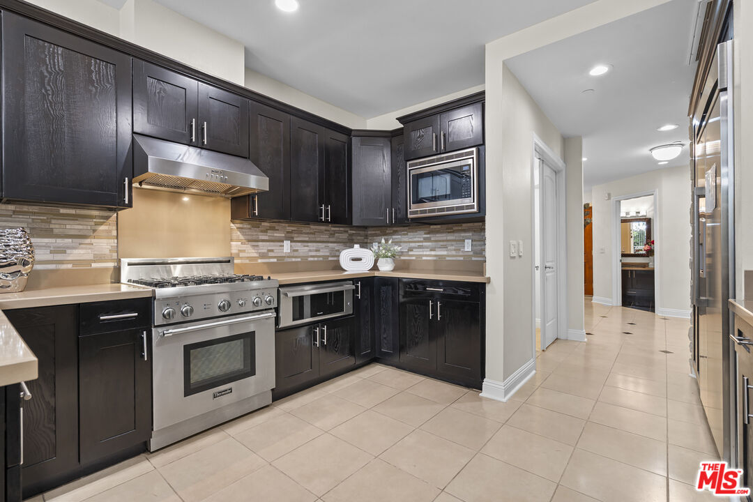 4848 Wilshire Boulevard, Unit 102 Los Angeles, CA 90036 - Photo 20 of 47 a kitchen with stainless steel appliances granite countertop wooden cabinets a stove top oven and granite counter tops