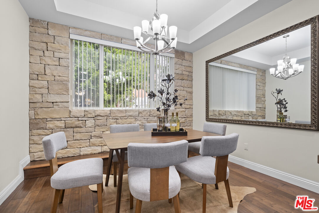 4848 Wilshire Boulevard, Unit 102 Los Angeles, CA 90036 - Photo 22 of 47 a dining room with furniture a chandelier and wooden floor