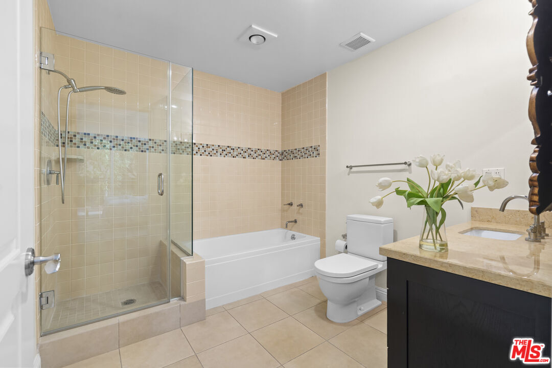 4848 Wilshire Boulevard, Unit 102 Los Angeles, CA 90036 - Photo 36 of 47 a bathroom with a granite countertop sink a toilet and shower
