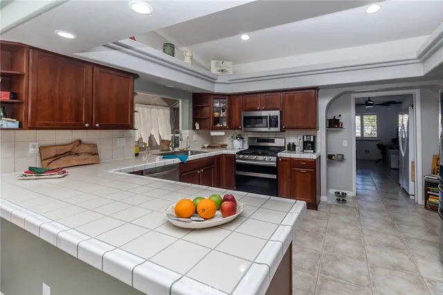 a kitchen with stainless steel appliances a stove a sink a microwave and wooden cabinets