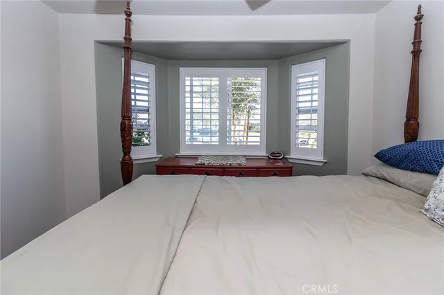 a view of a bedroom with a bed and a window